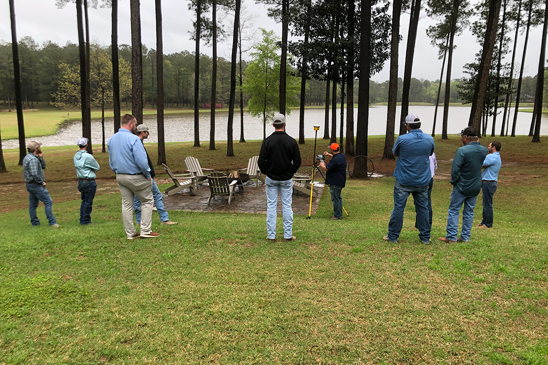 SITECH Louisiana team members watching a construction technology demonstration outdoors. Training